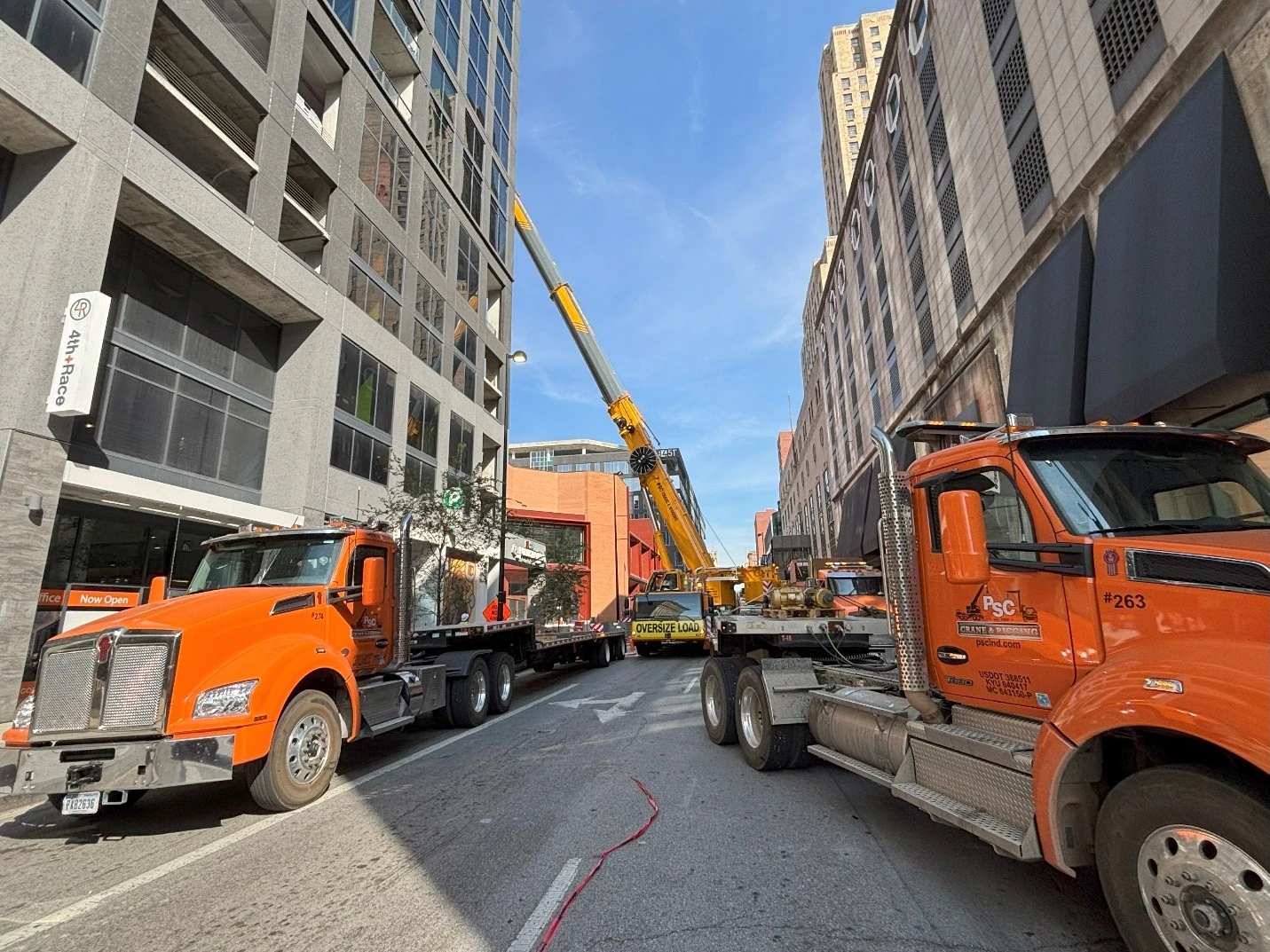 Big orange trucks parked on either side of city street.